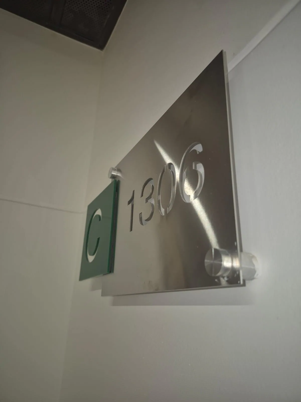 Placa metálica de señalización interior con número 1306